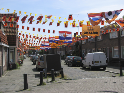 905353 Gezicht in de met oranje vlaggetjes versierde Merwedestraat te Utrecht. De versieringen zijn aangebracht naar ...